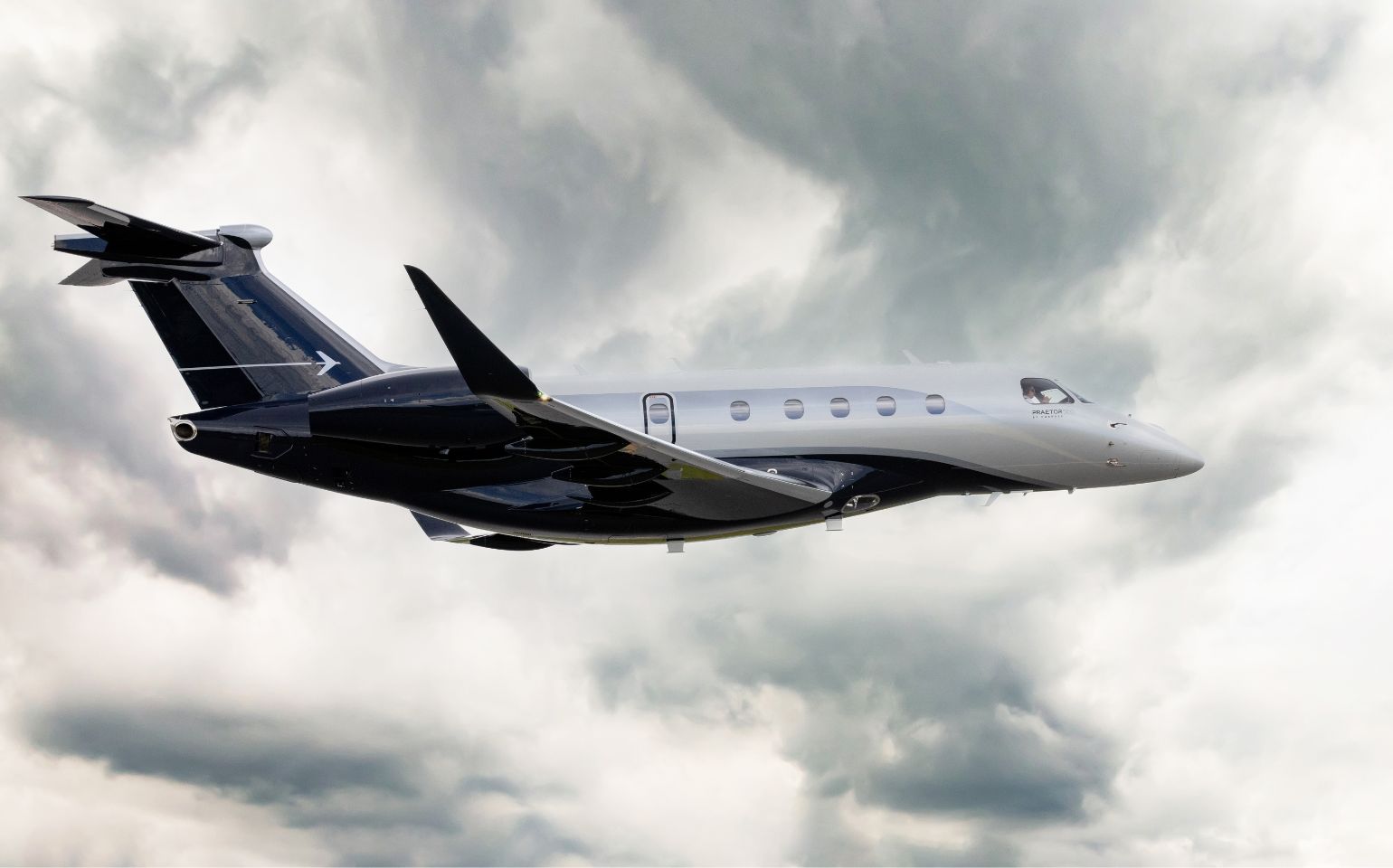 Embraer Praetor 500 private jet charter flying above the clouds