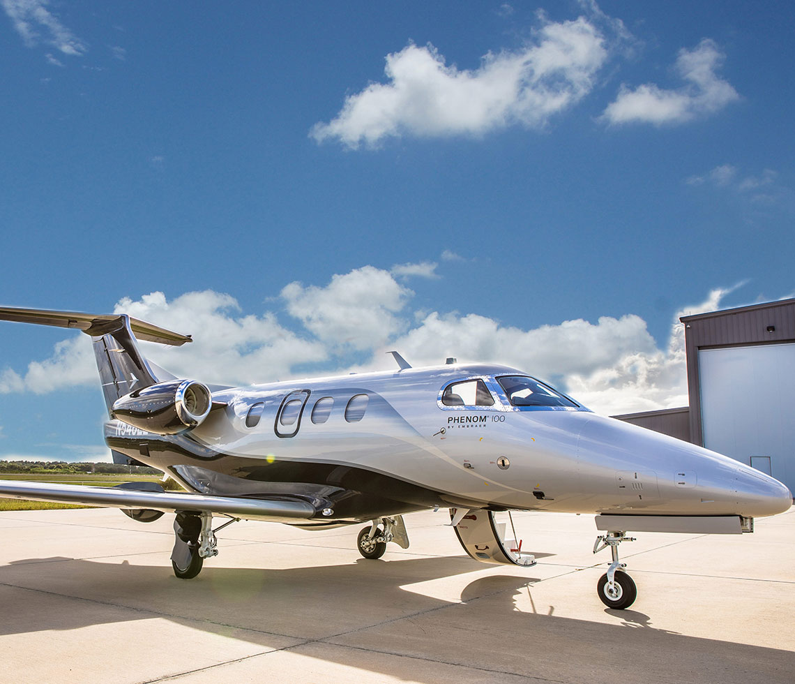 closeup of Embraer Phenom 100 parked at private jet hangar