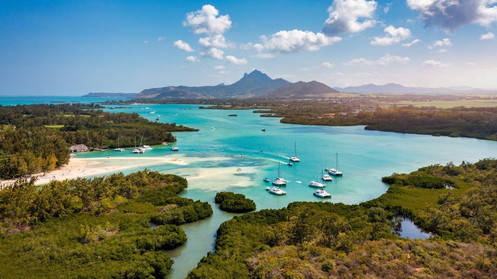Ile aux Cerfs island with idyllic beach scene, yachts sailiing in turqoise waters