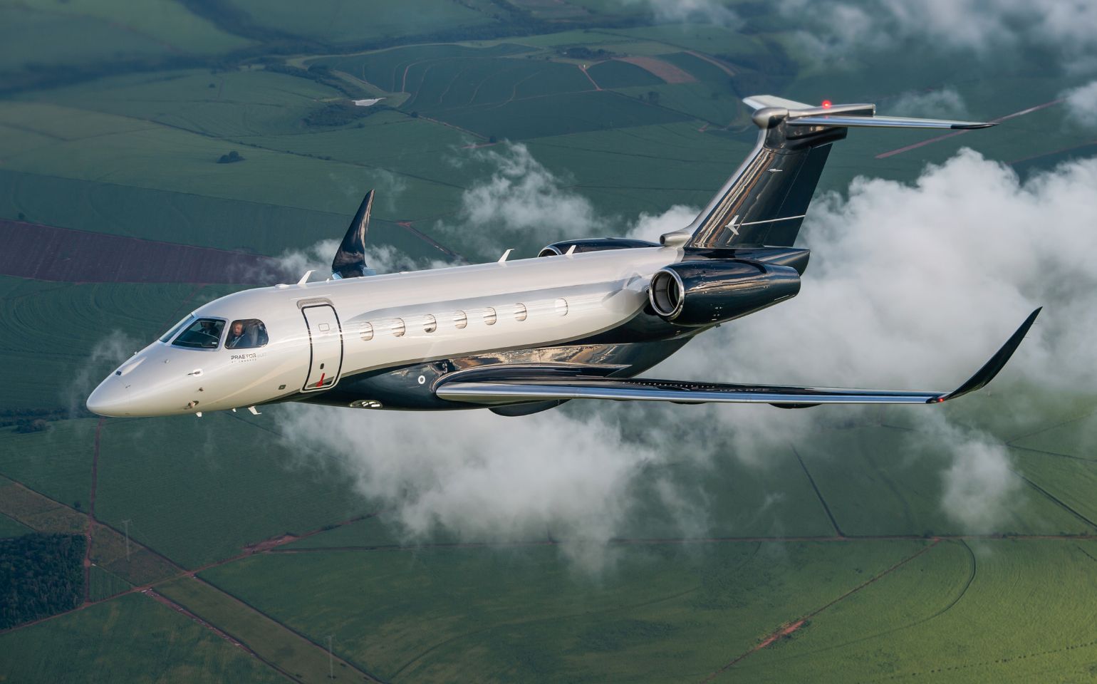 Embraer Praetor 600 private jet charter flying above clouds